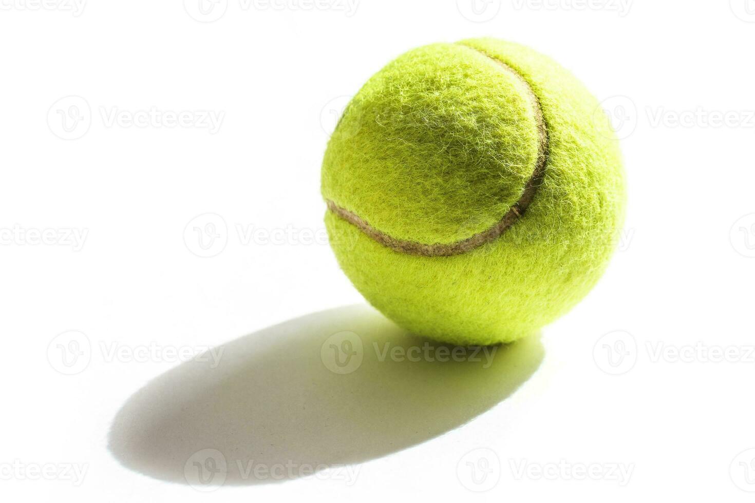 Tennis yellow ball and shadow from it on white background isolated photo