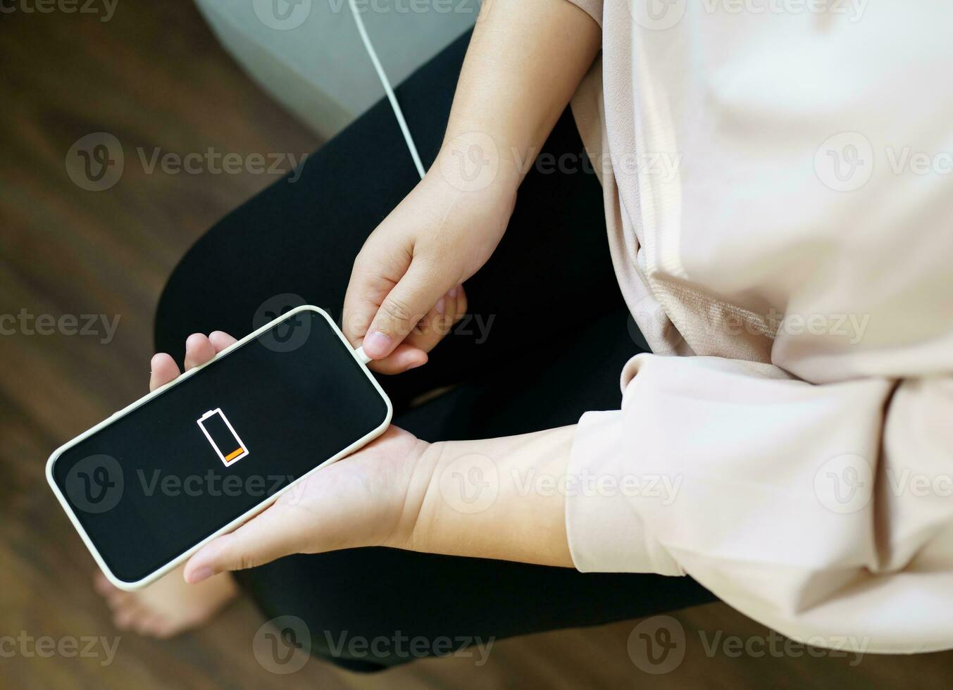 Woman hands Charging mobile phone battery with low battery. plugging a charger in a smart phone  with energy bank powerbank power charger Modern lifestyle energy technology concept photo