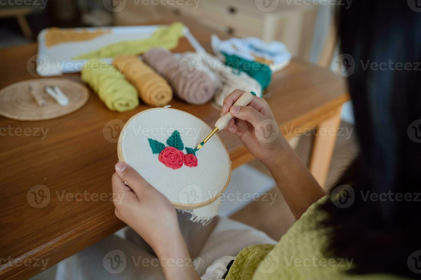 puñetazo aguja. asiático mujer haciendo hecho a mano pasatiempo tejido de punto en estudio taller. diseñador lugar de trabajo hecho a mano arte proyecto bricolaje bordado concepto. foto