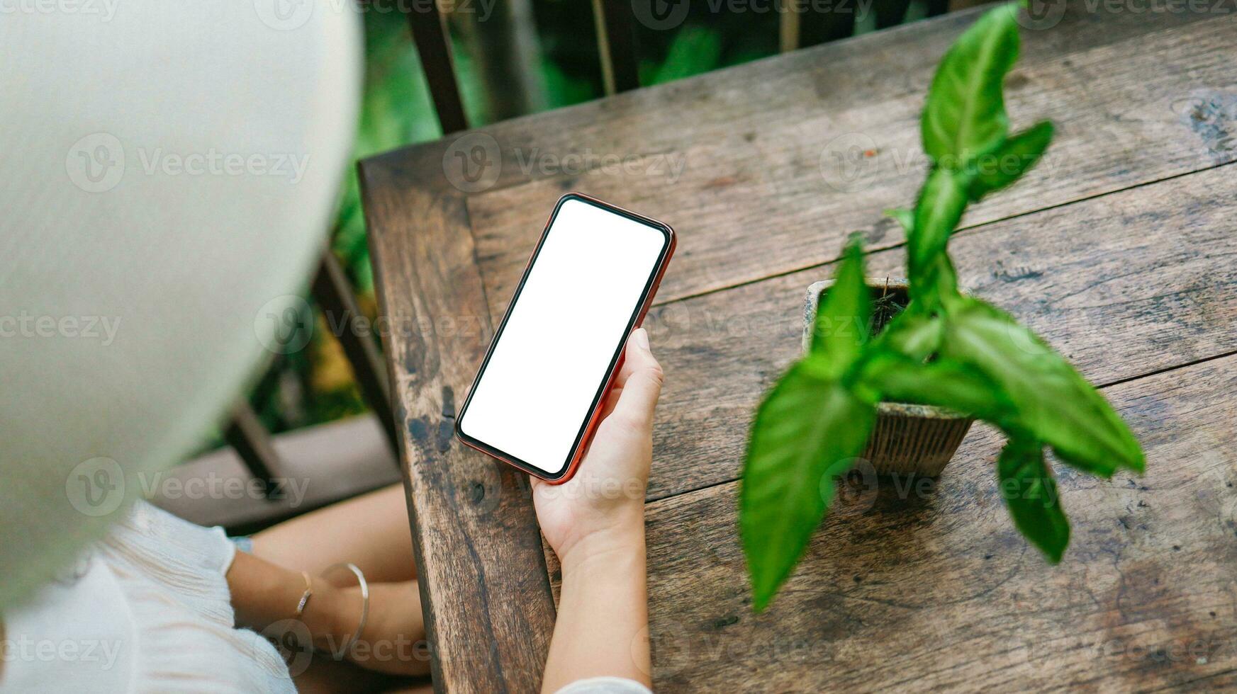 vacation concept Woman hand holding black smartphone relax at hotel resort photo