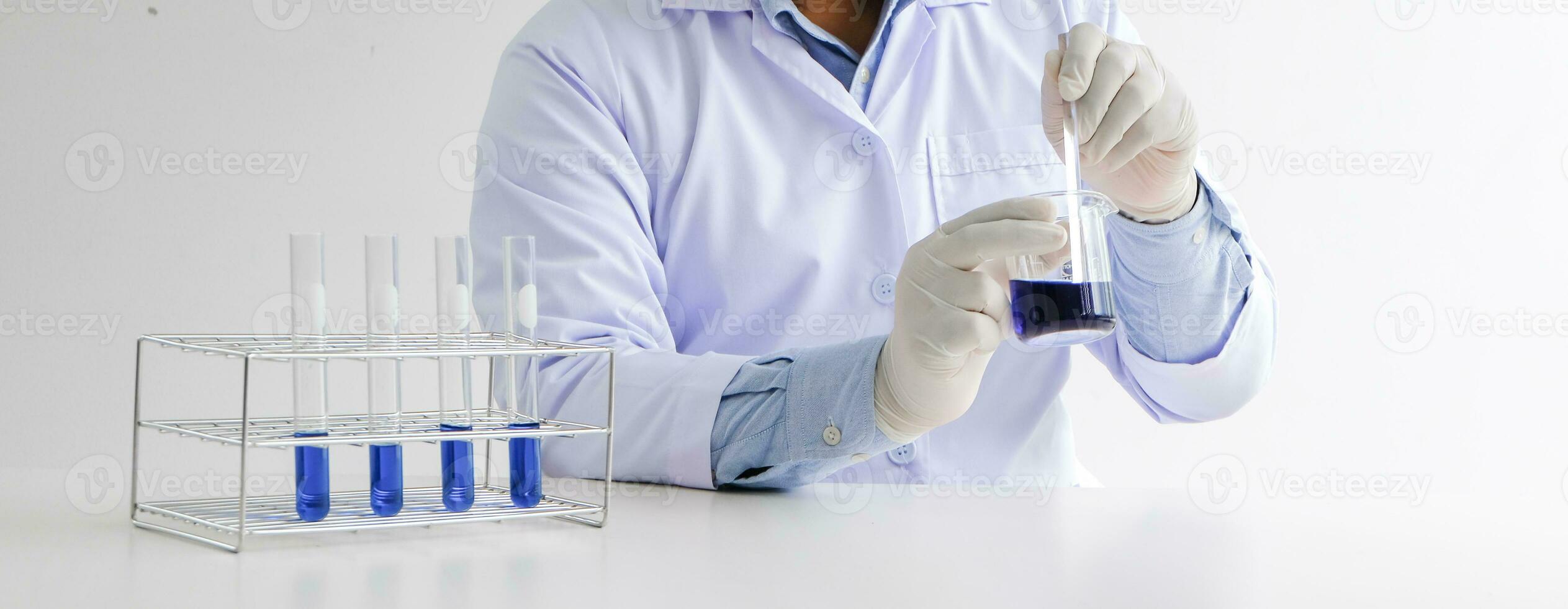 Science innovative Male medical or scientific laboratory researcher performs tests with blue liquid in laboratory. equipment science experiments technology Coronavirus Covid-19 vaccine research photo