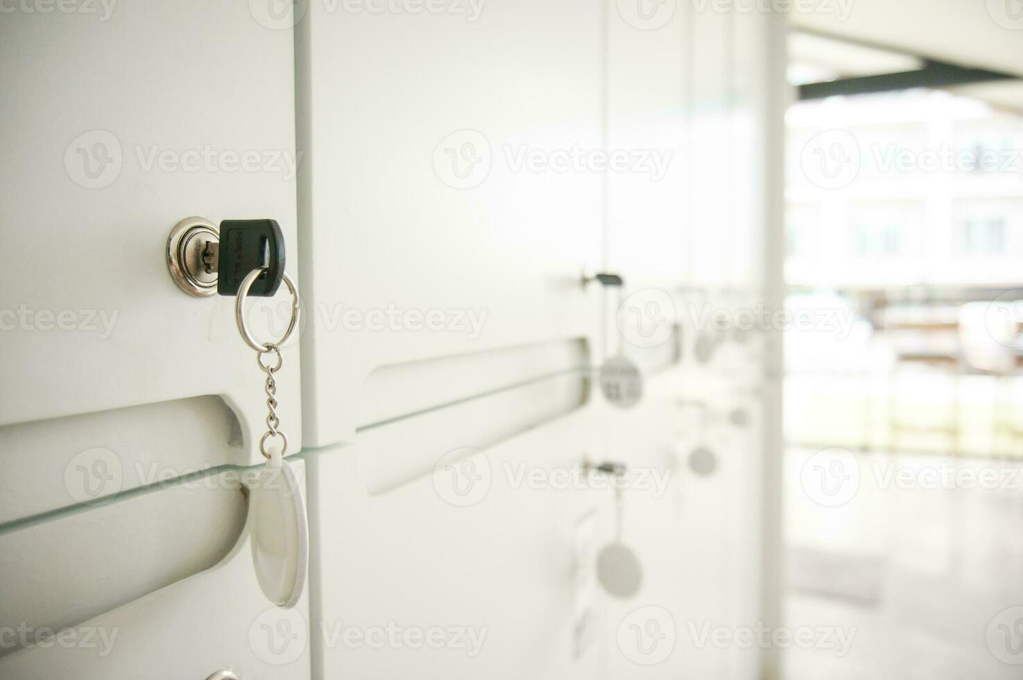Key in keyhole on locker door. Keys stuck in a lock photo