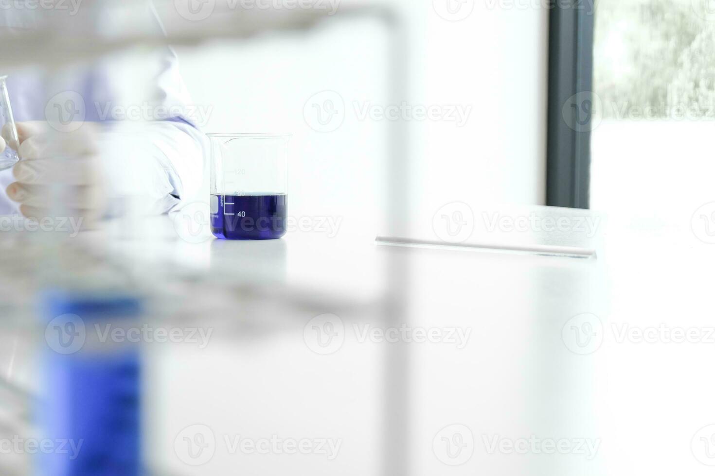 Science innovative Male medical or scientific laboratory researcher performs tests with blue liquid in laboratory. equipment science experiments technology Coronavirus Covid-19 vaccine research photo