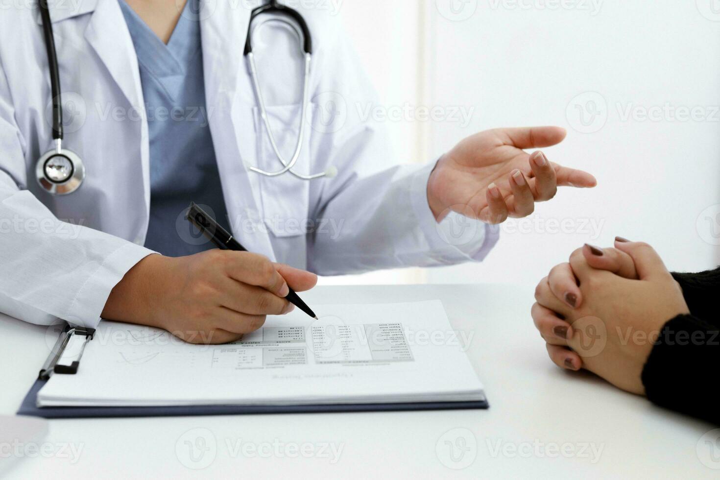 Doctor talking with  patient in doctors office photo