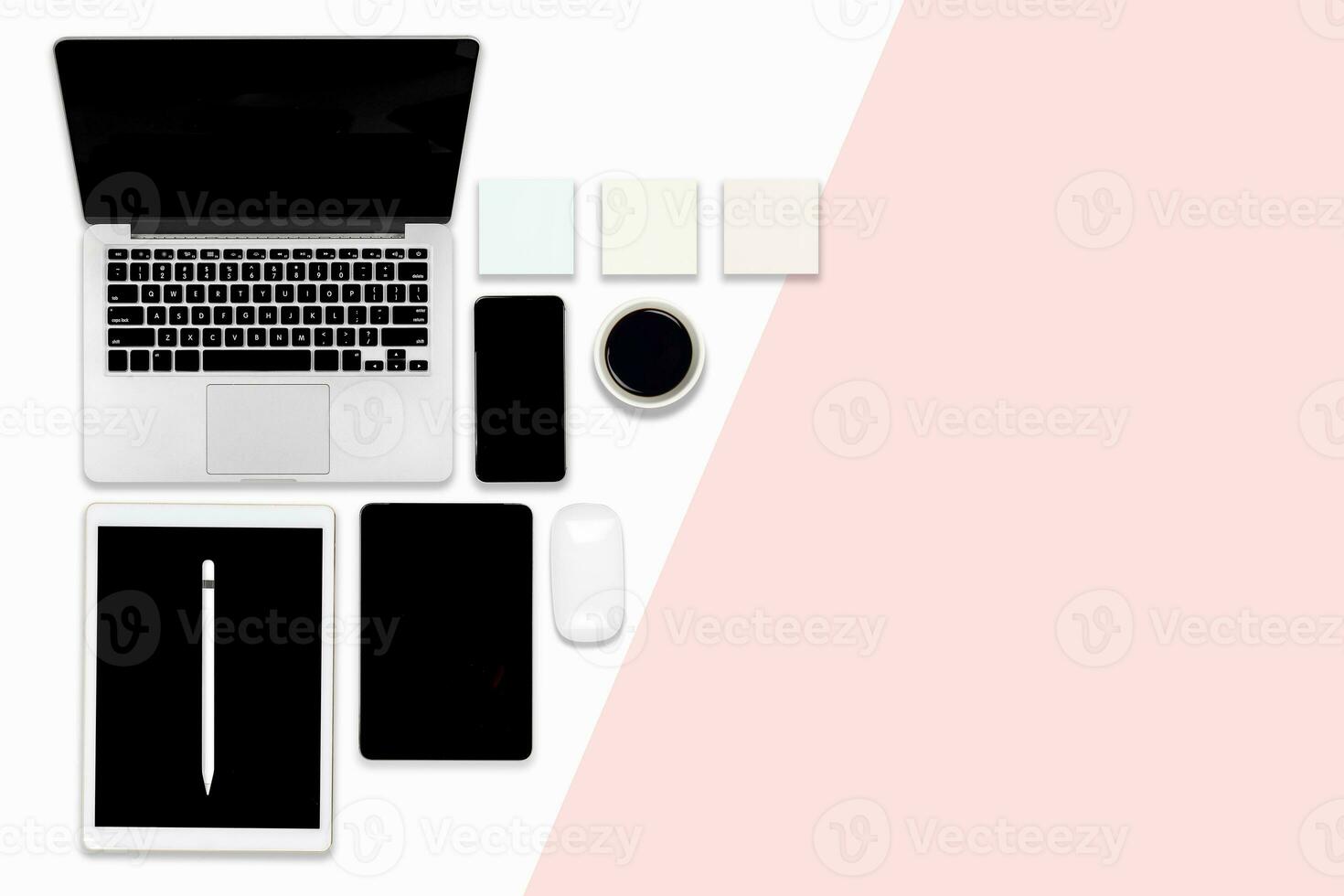 Flat lay photo of Office table with laptop computer, digital tablet, and mobile phone on modern two tone background.