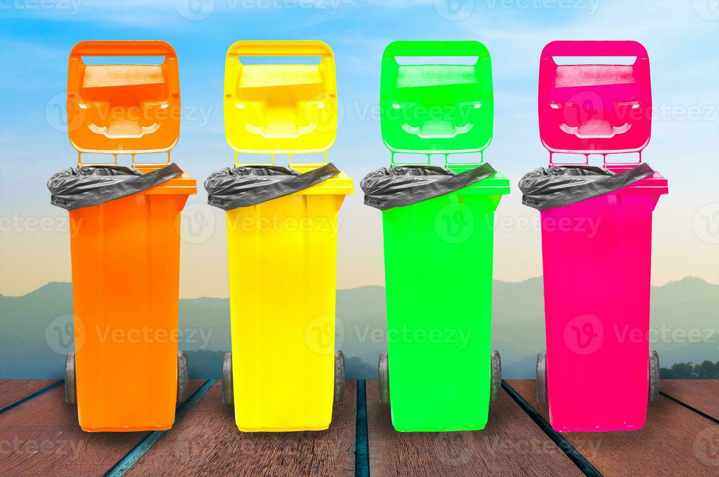 Collection of large colorful trash cans garbage bins on wooden with Landscape background photo