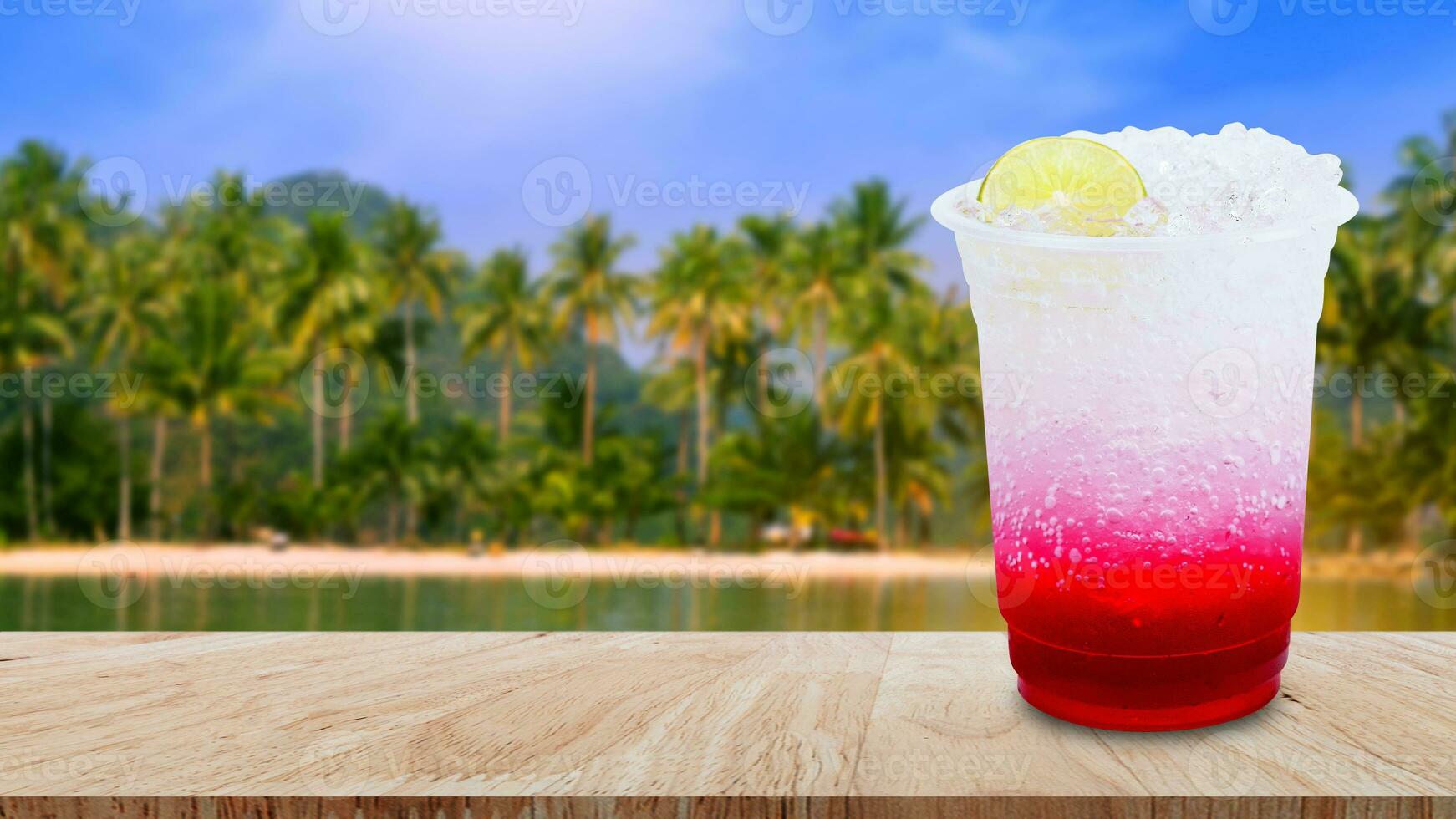 Italian soda made from fruit syrup drink mix in plastic cup on wooden table. Lemon, Red cocktail summer refreshment drink, Summer drinks with ice photo