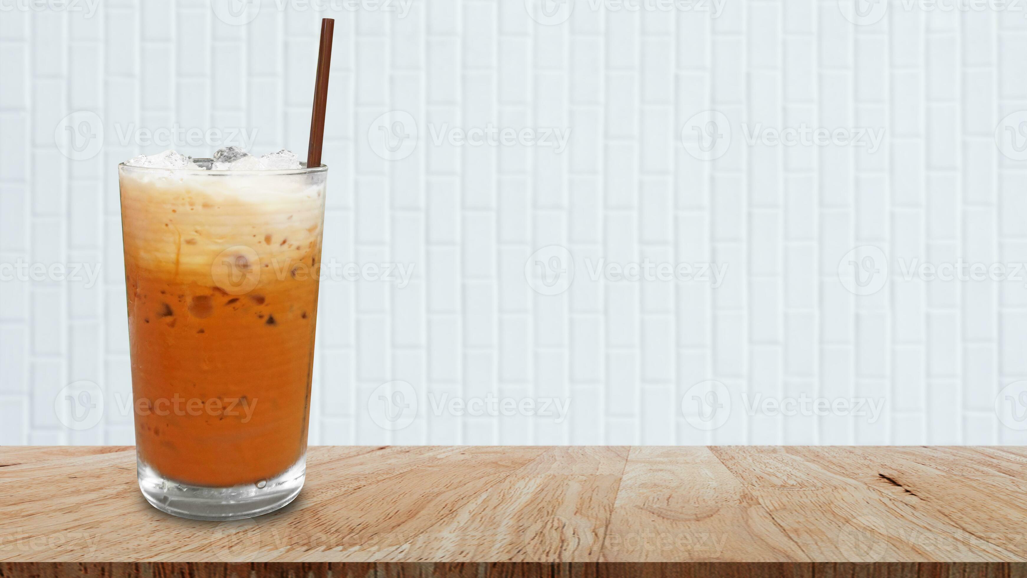 Iced thai milk tea in glass, Milk ice tea, Cheddar is a traditional Thai drink on wooden table
