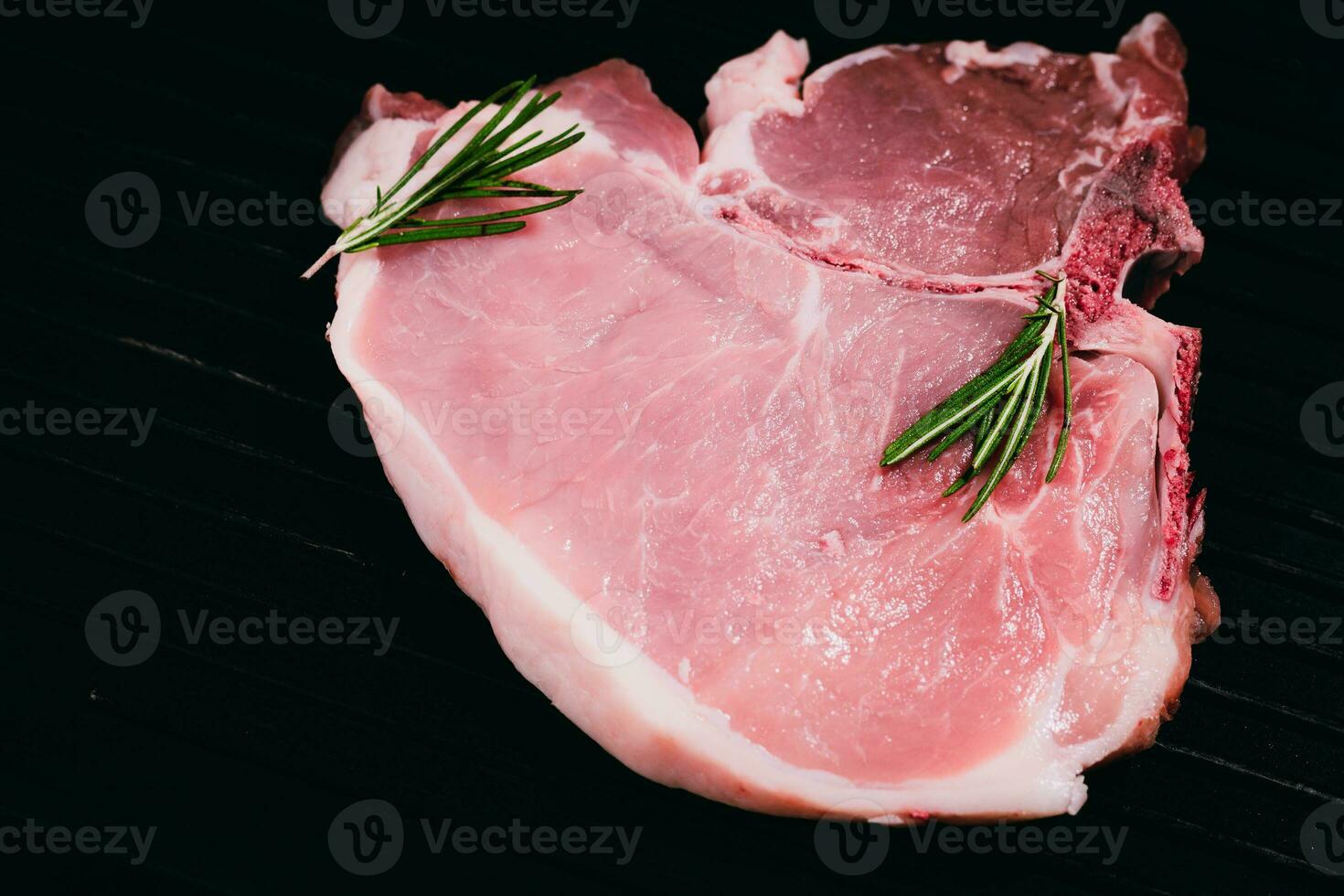 Top view raw pork chop steak on black background. photo