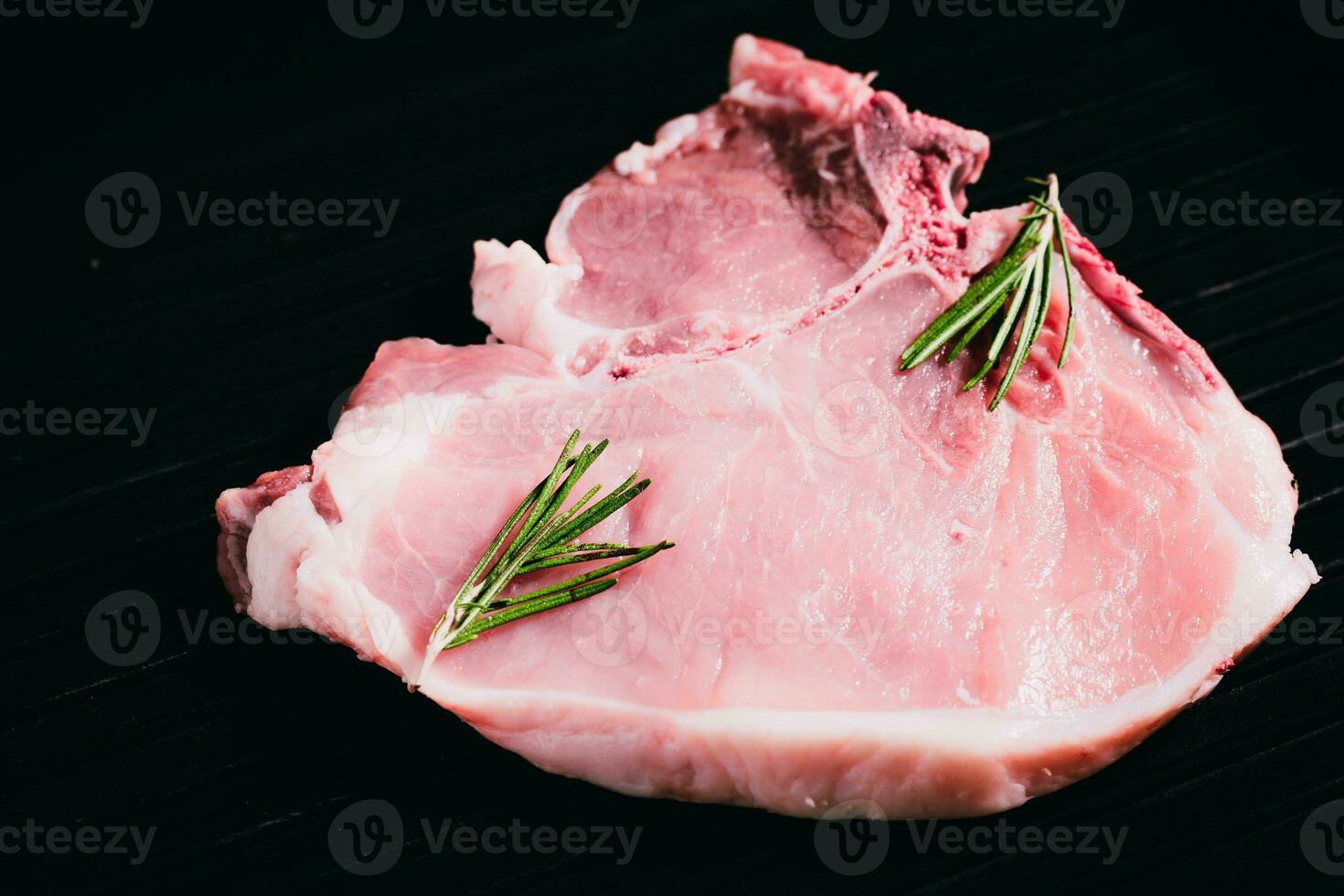 Top view raw pork chop steak on black background. photo