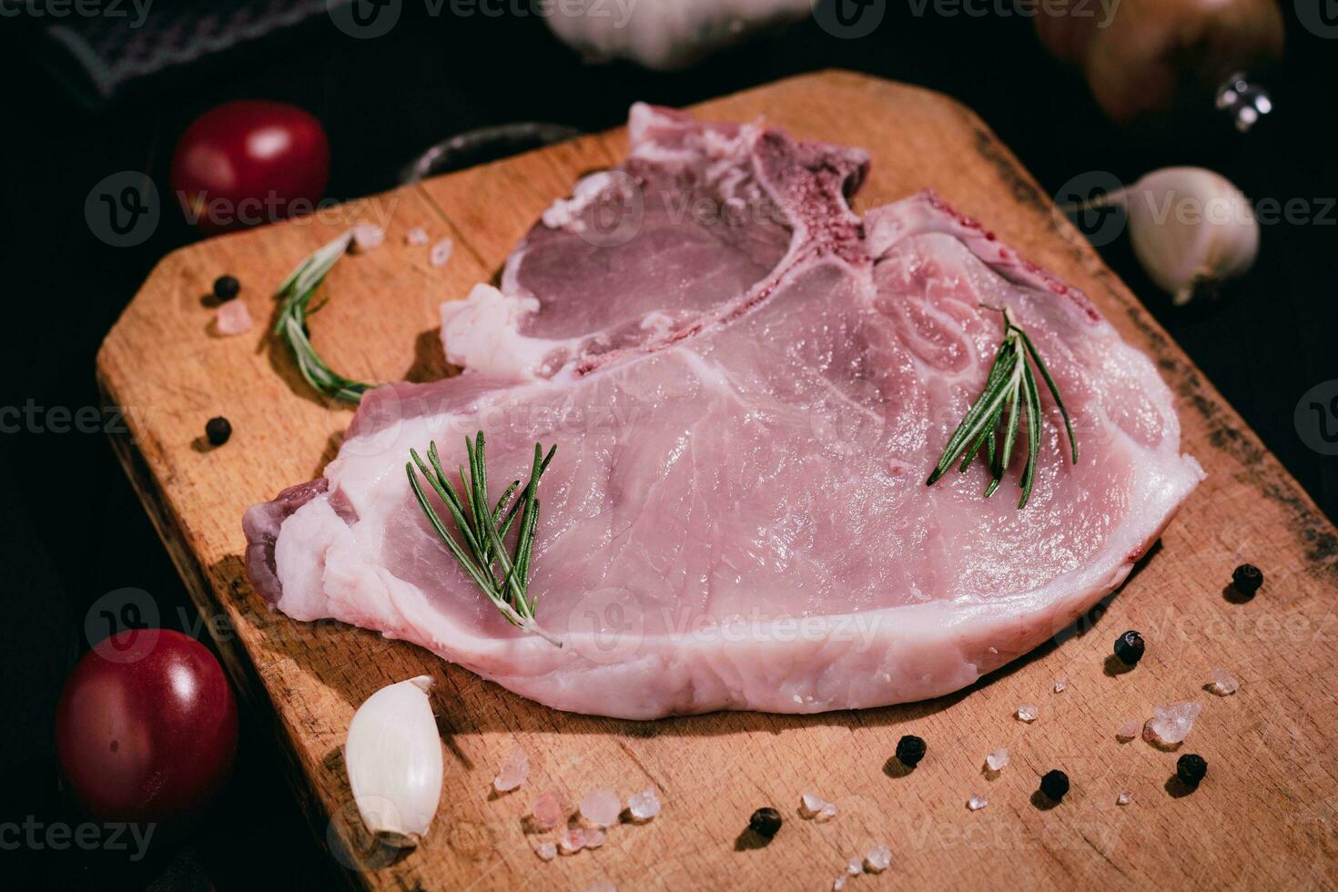 Pork chops on a cutting board with garlic, spices. Selective focus photo