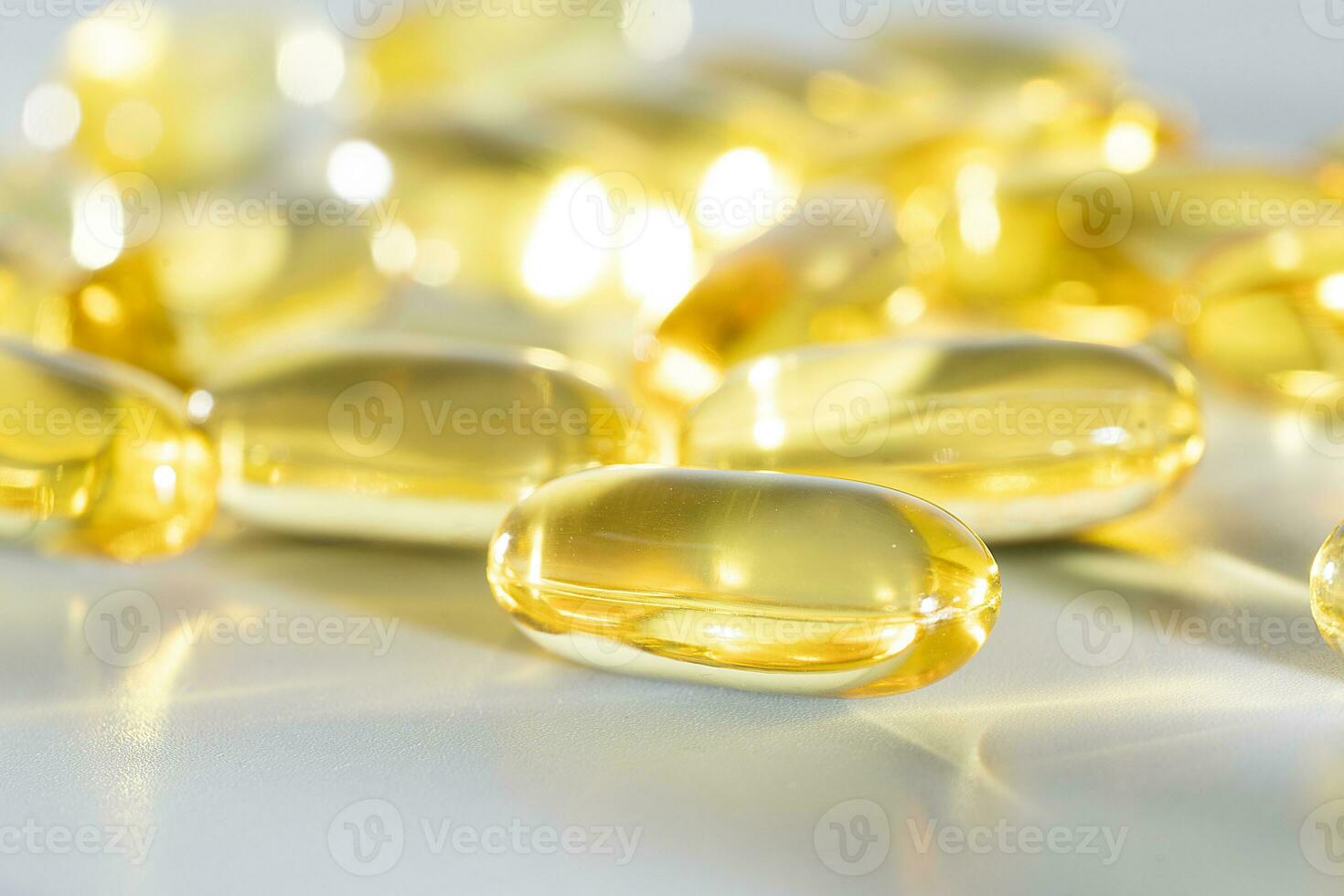 Fish Oil Omega 3 on white background, vitamin D yellow supplement gel capsules, macro shot photo