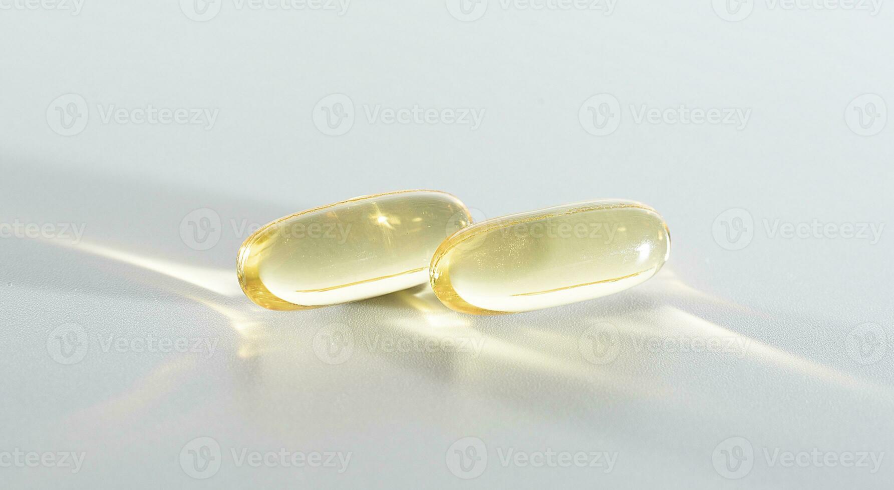 Vitamin D yellow supplement gel capsules, Fish Oil Omega 3 on white background, macro shot photo