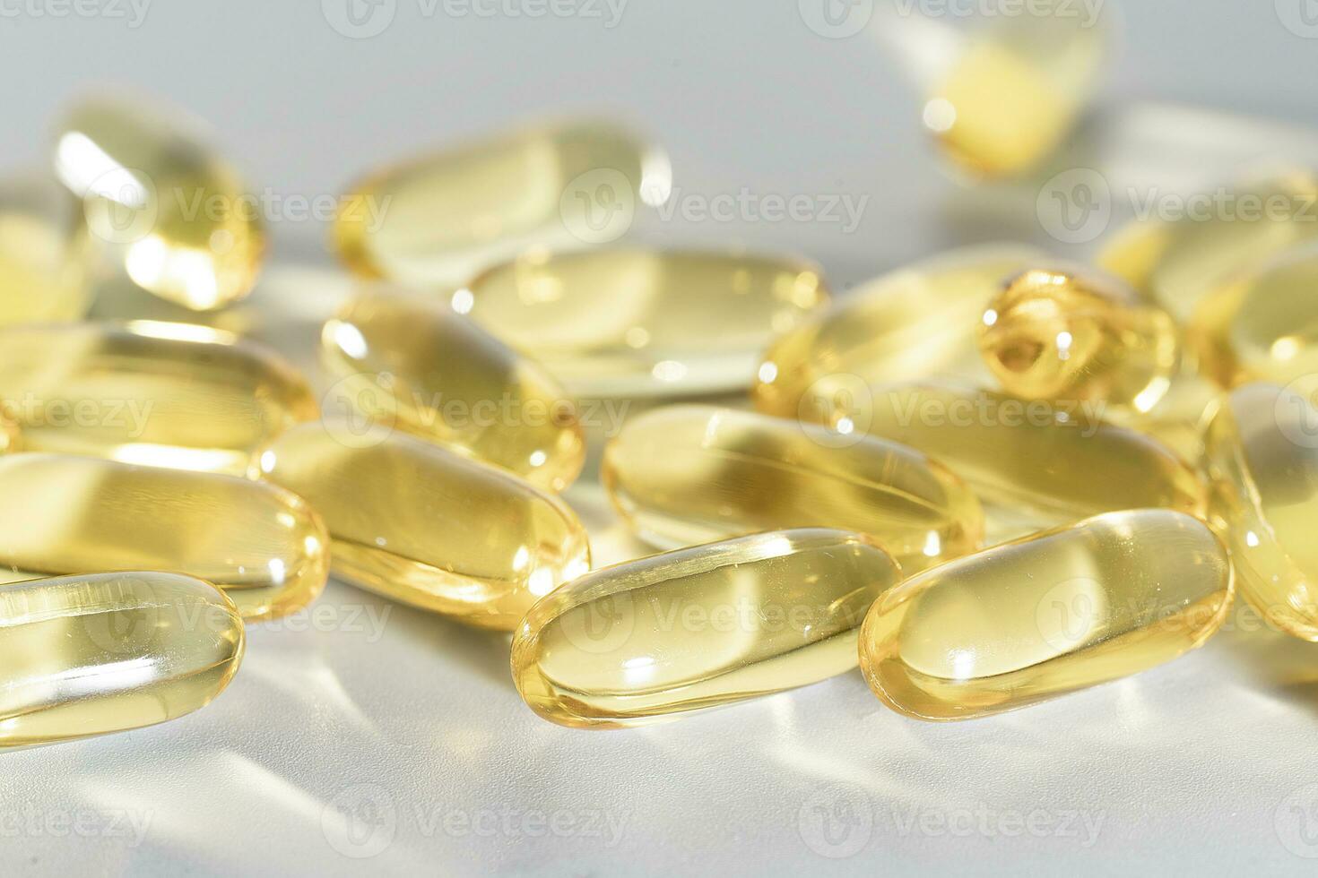 Fish Oil Omega 3 on white background, vitamin D yellow supplement gel capsules, macro shot photo