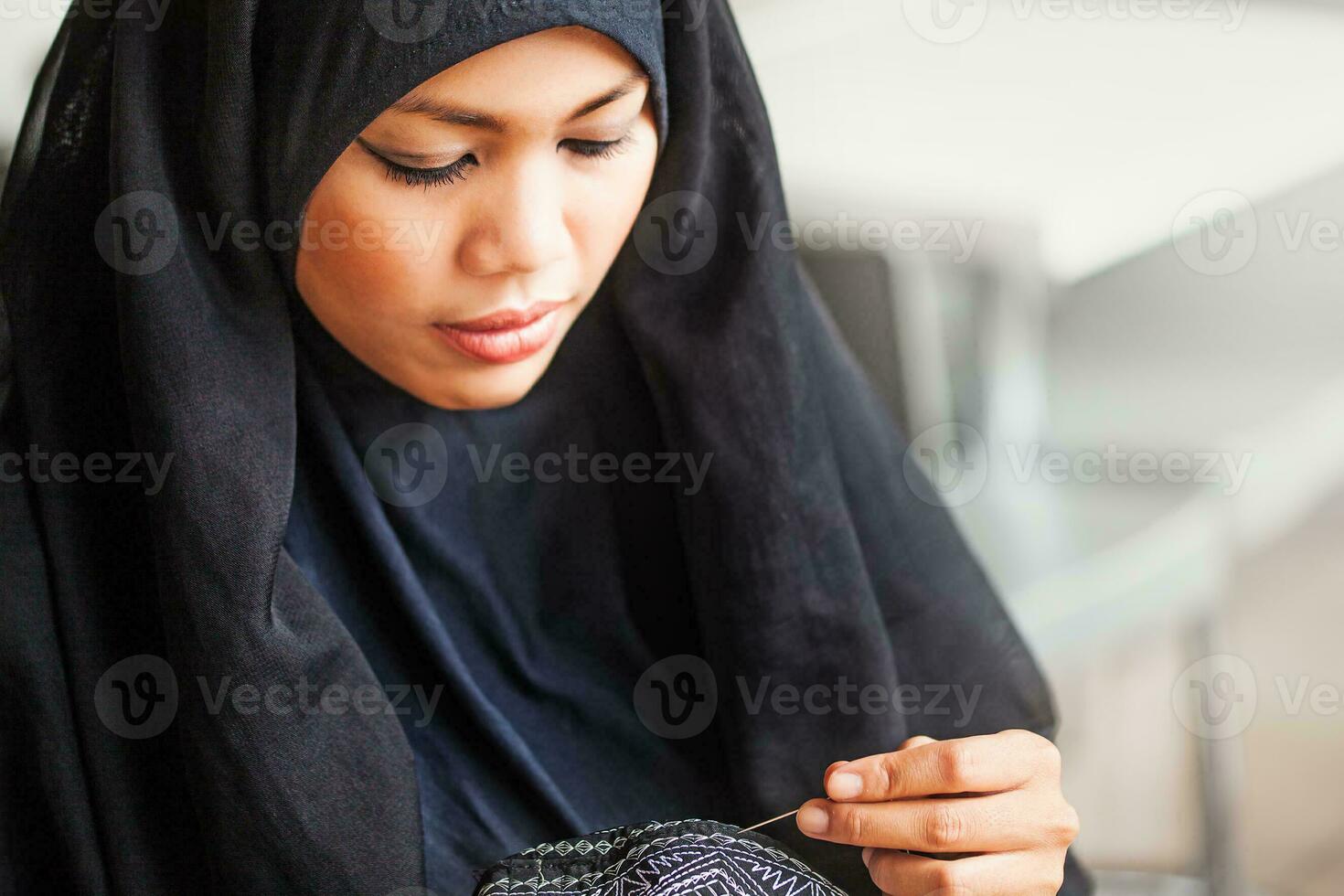 joven árabe Burka revestido mujer de coser un casquete foto
