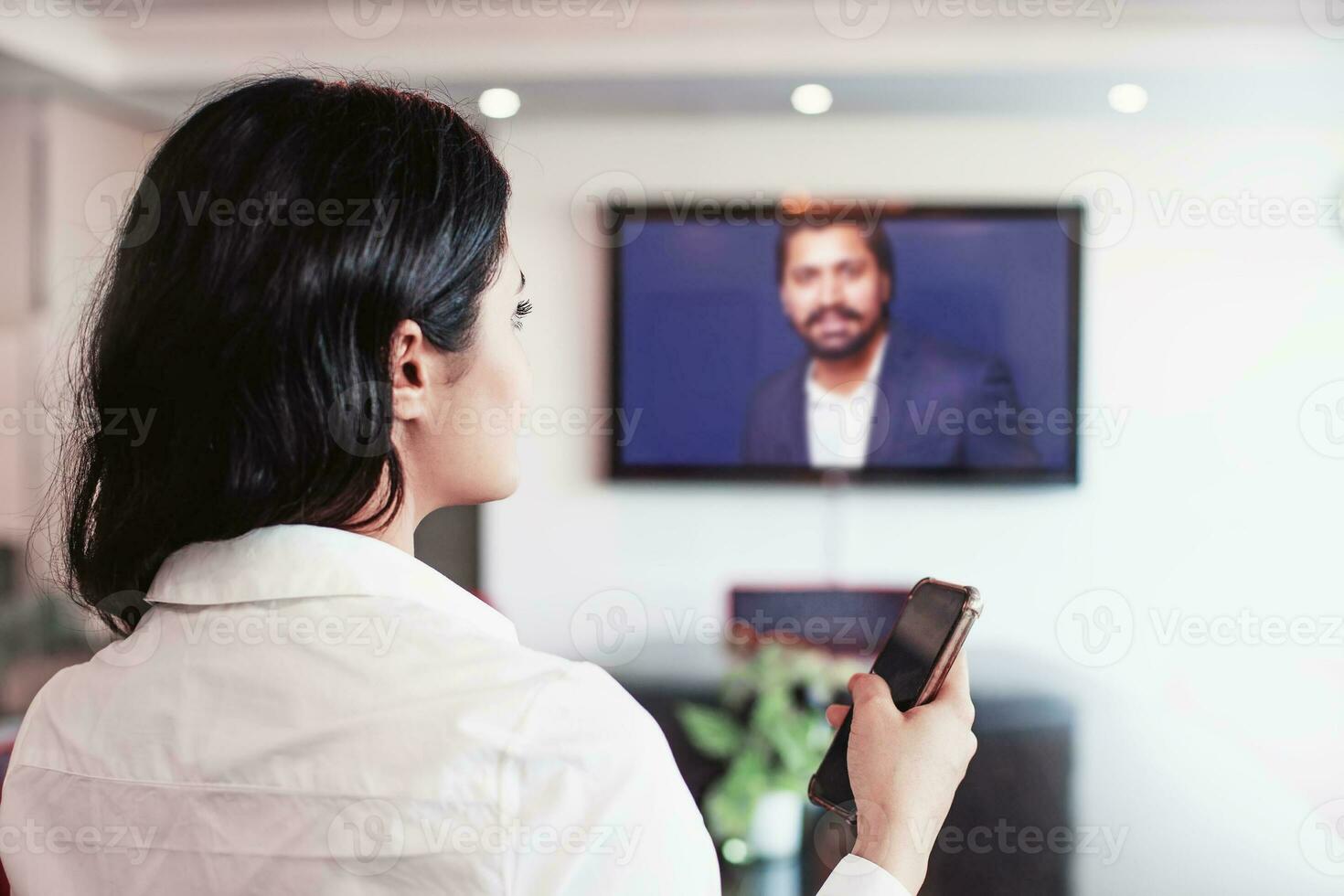 Young indian woman doing video conference with director of her company online on a big screen tv photo