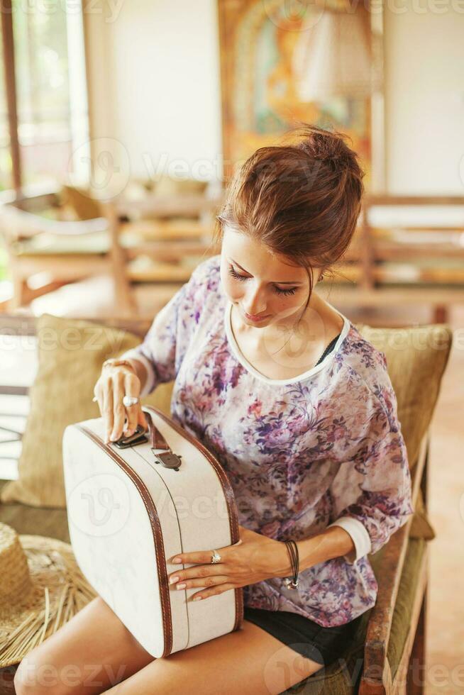 Young woman at home packing bag photo