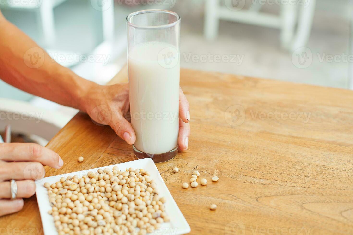 female hand holding a glass of soya milk photo