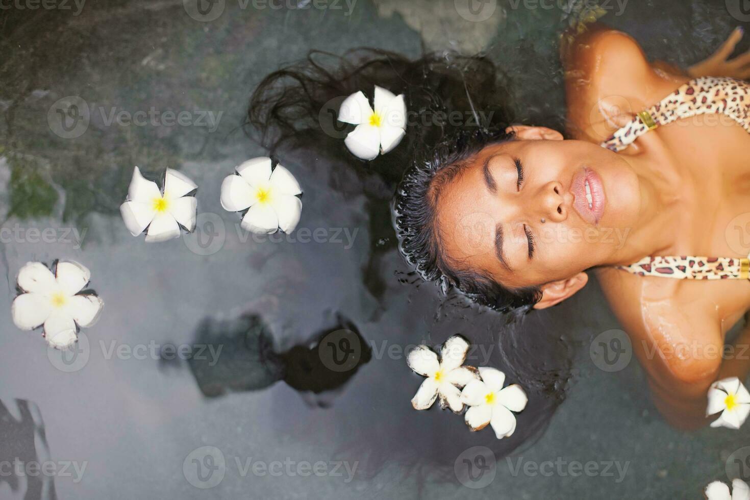 hermosa exótico mujer teniendo bañera en un lujo spa salón foto