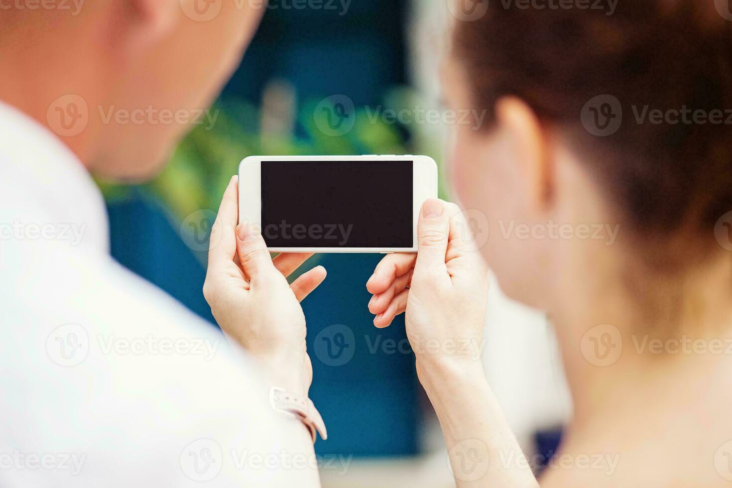 two people using a phone - blank screen app design mockup photo