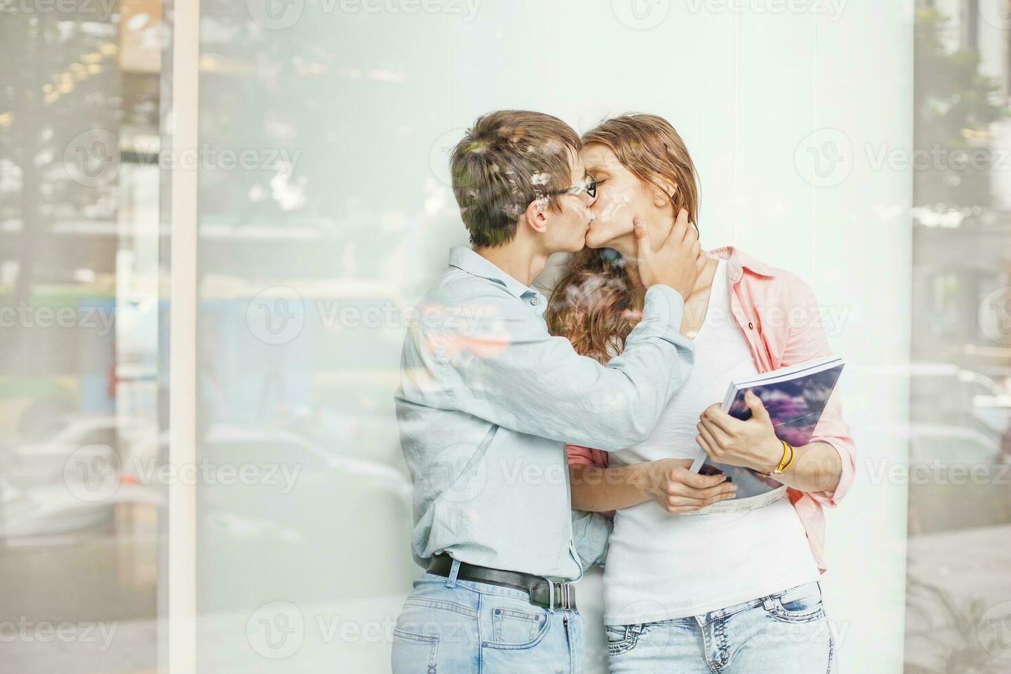 Students kiss. Two people kissing, view through the window photo