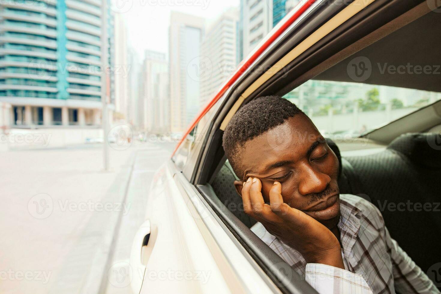 exhausted young african man sleeping in taxi photo