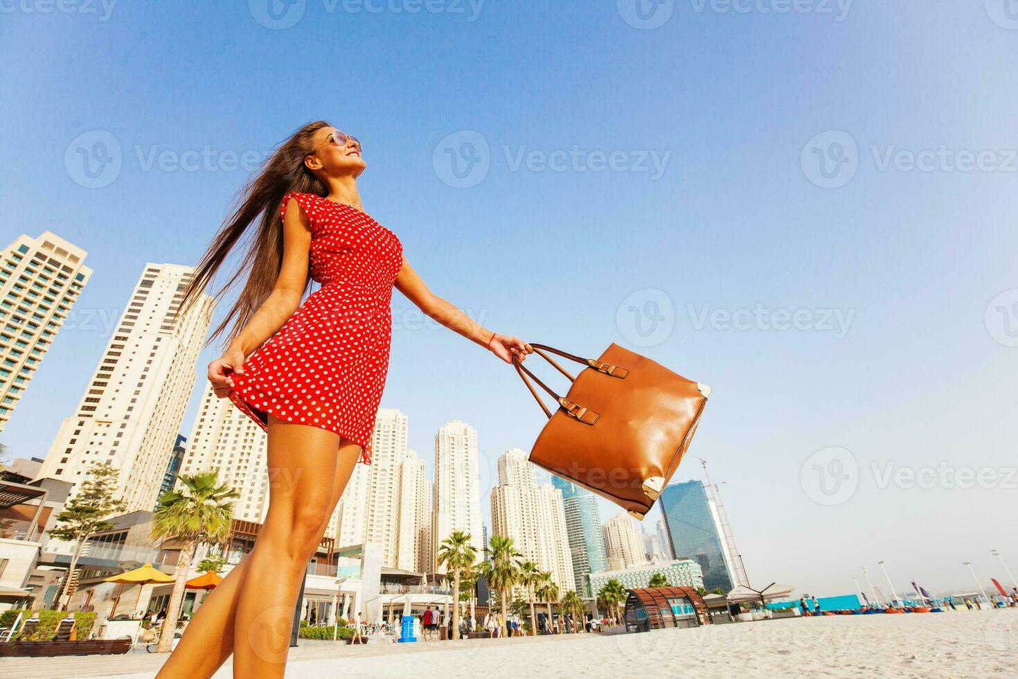 beautiful young woman enjoying a walk on a beach in Dubai photo