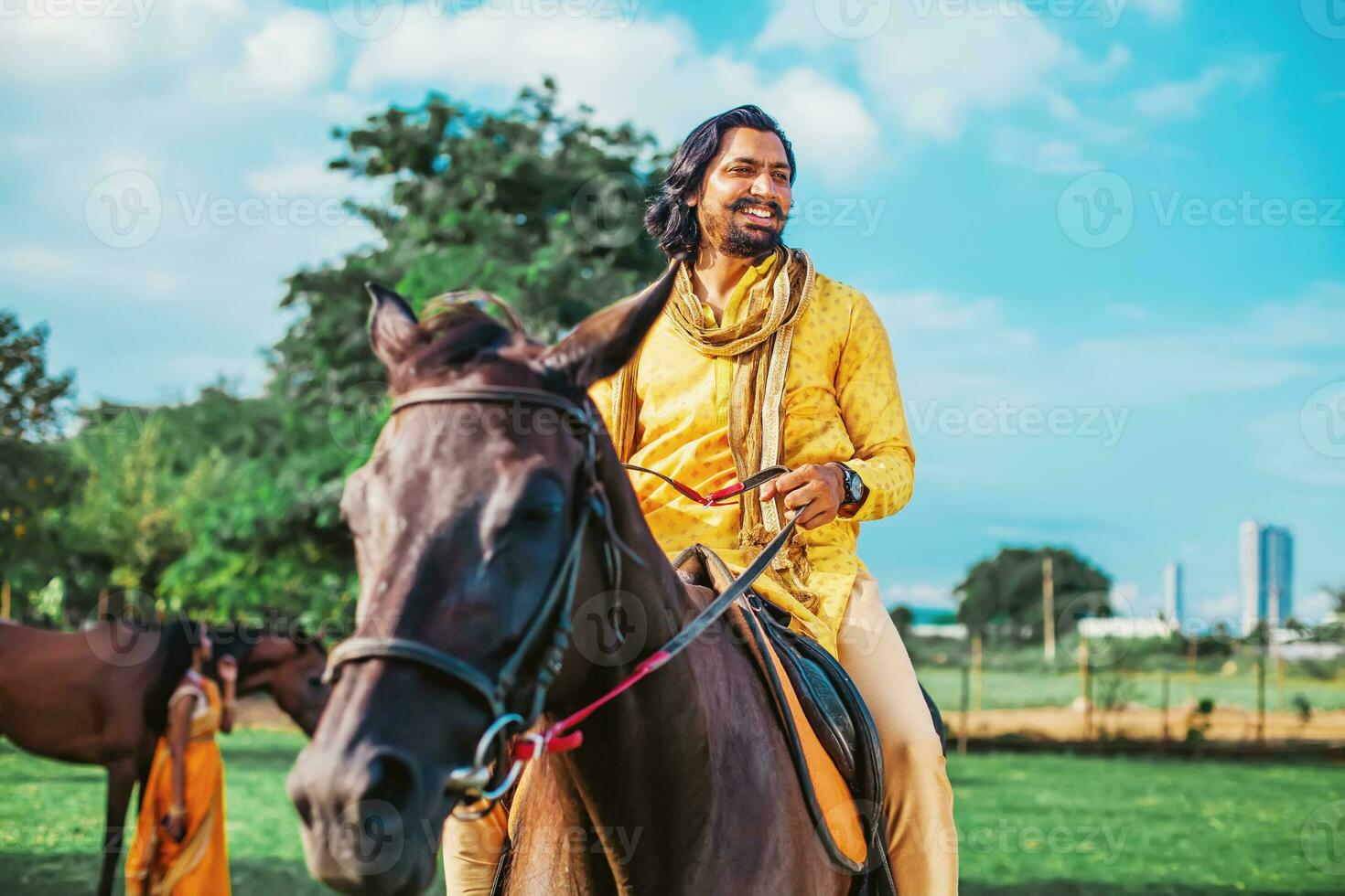 Handsome bearded Indian man riding a horse in an equestrian club photo