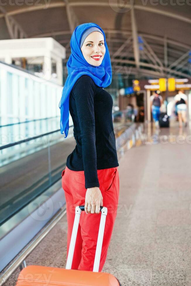 muslim woman walking with her bag in airport photo