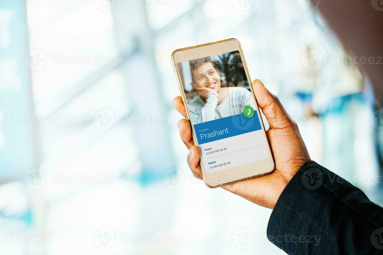 Calling a friend. Hand holding phone with video call with young indian man photo