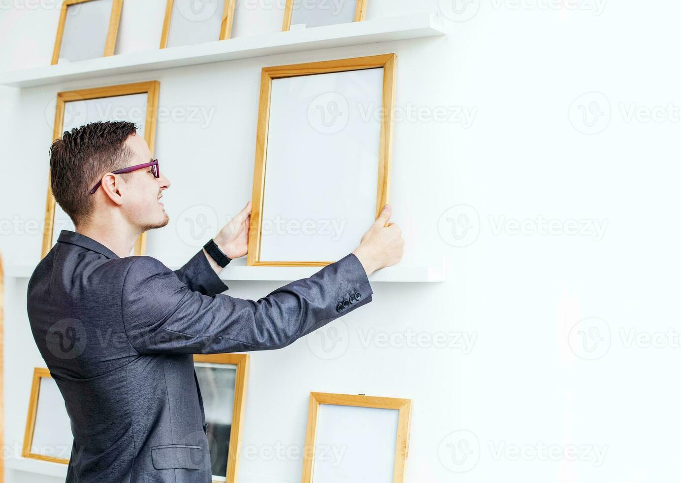 young man hanging a blank poster in exhibition hall photo