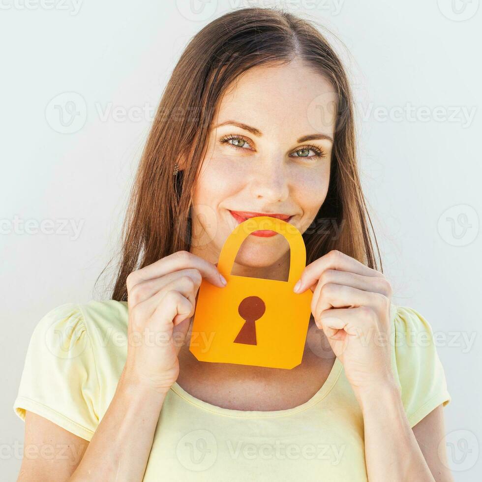 funny portrait of a woman keeping silence with the paper lock over her mouth photo