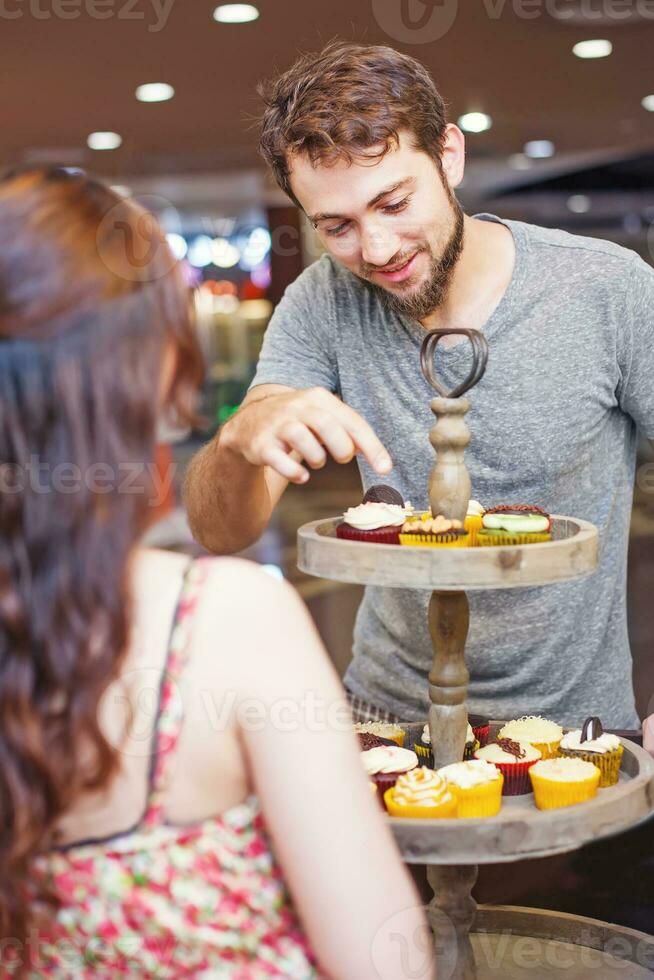 Customer chosing cupcakes in the shop photo