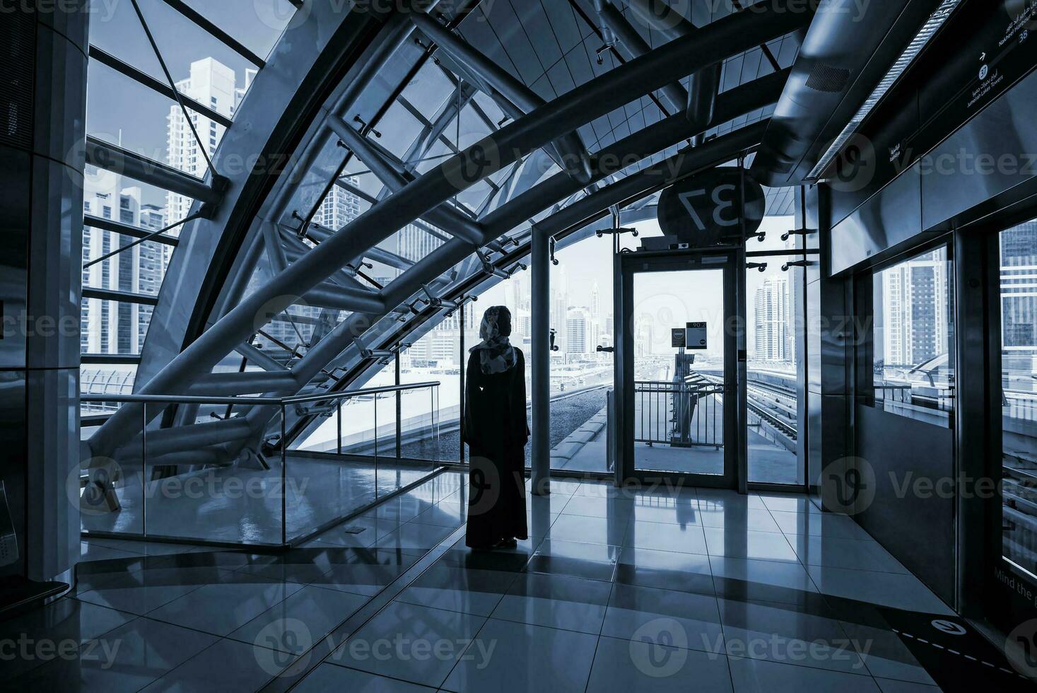 a young African woman wearing hijab standing on railway platform photo