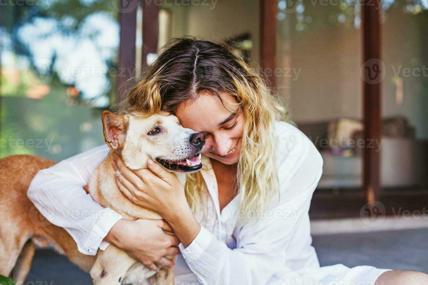 Beautiful caucasian woman hugging her mongrel dog pet photo