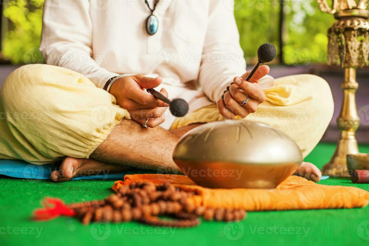 man playing mantras on a hang drum photo