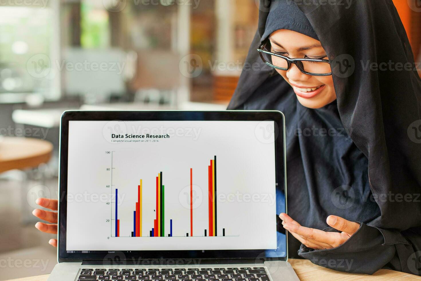 muslim female scientist showing statistical data on laptop photo