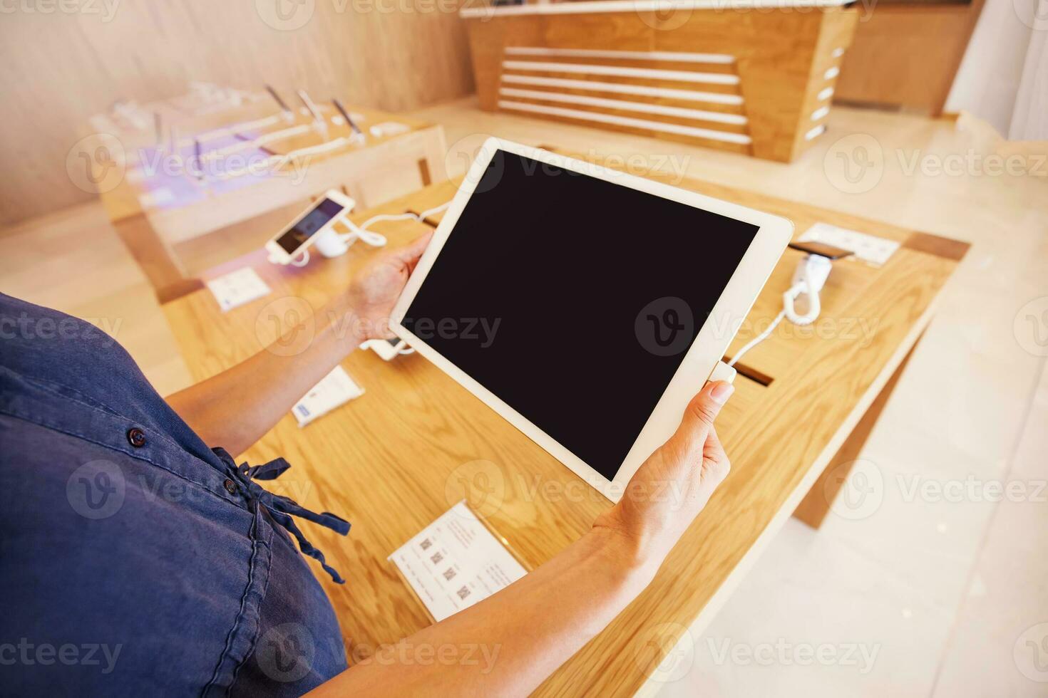 woman holding a tablet put up for demo in a store photo