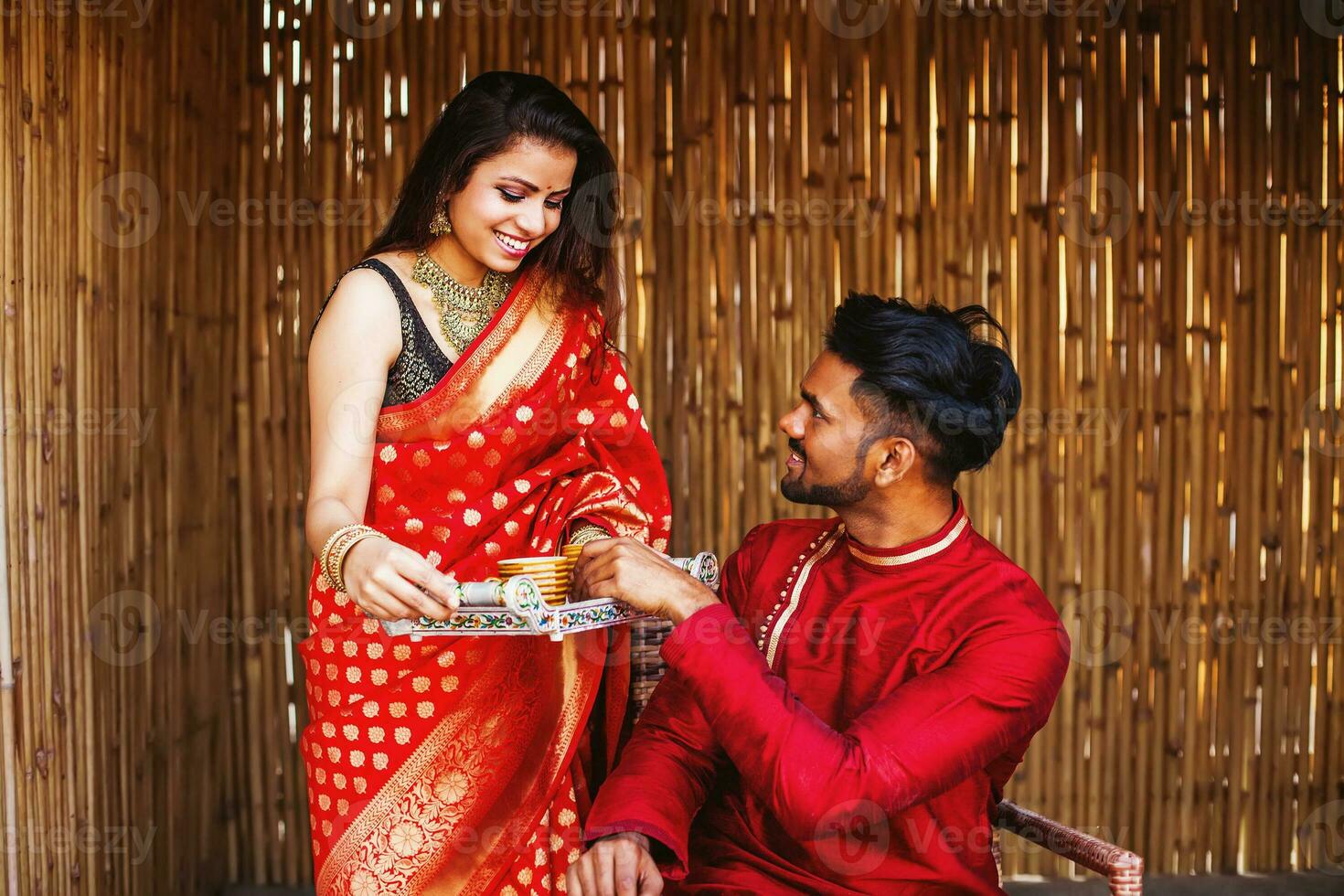 Beautiful Indian woman in a saree bringing tea to her husband in the morning photo