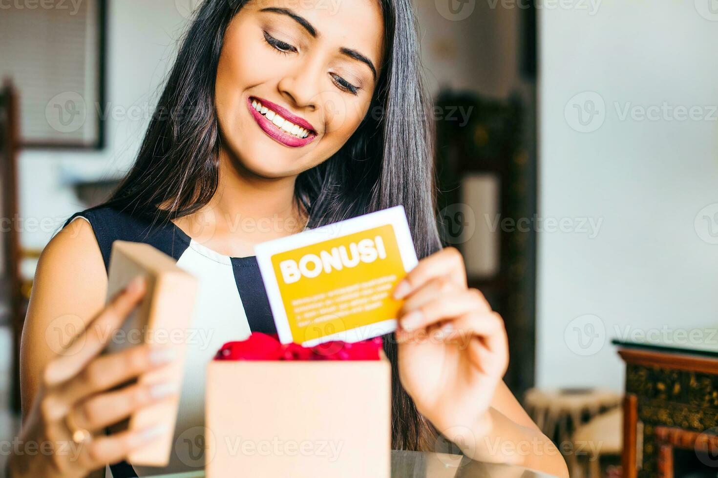 A happy young professional Indian woman after being awarded bonus photo