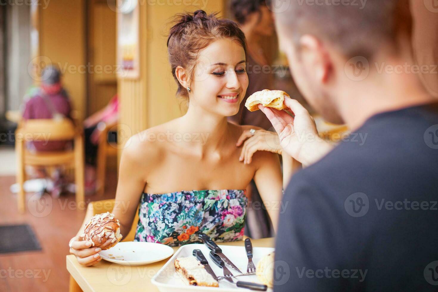 Couple feeding each other with the cake in restaurant photo