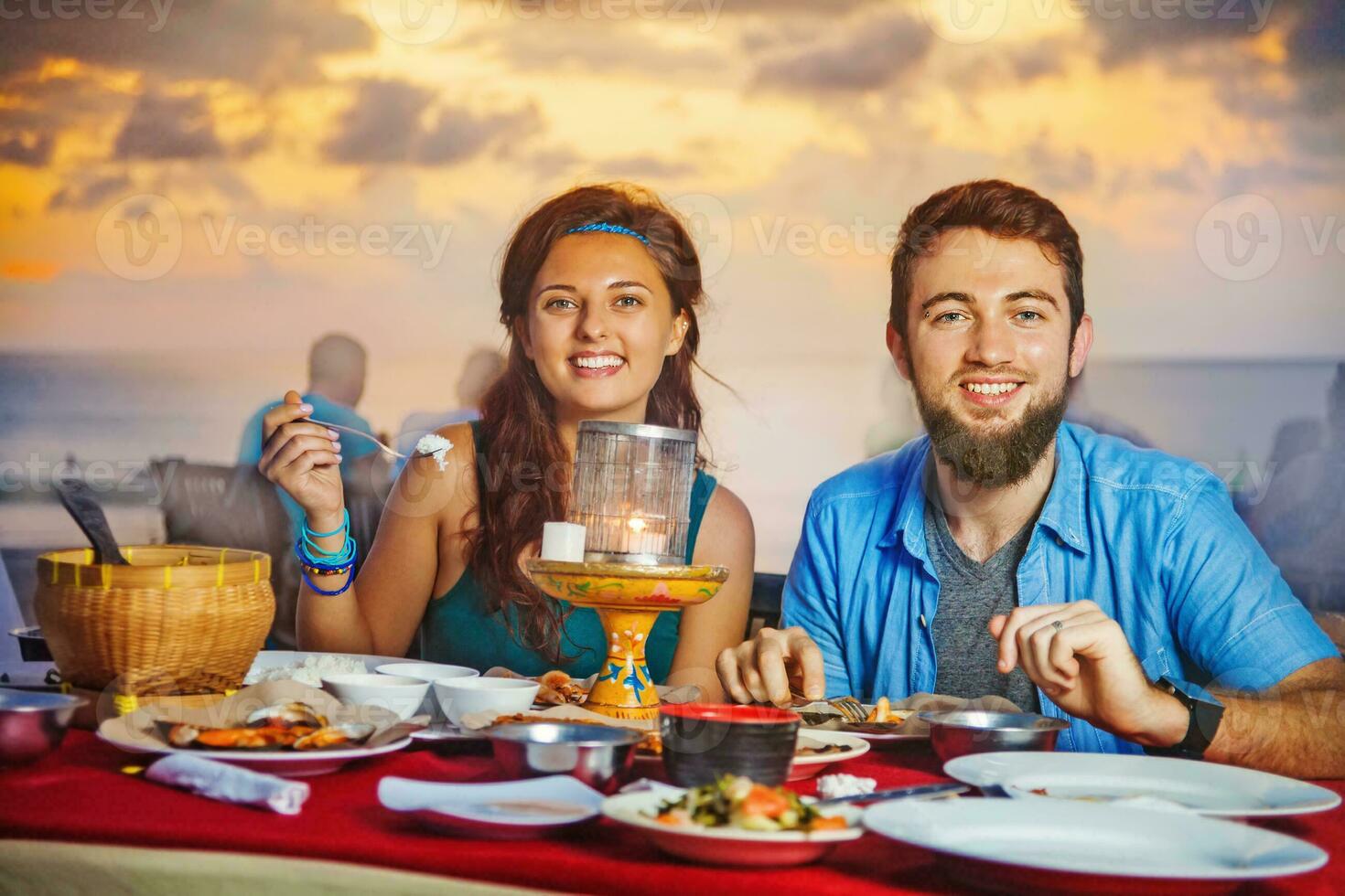 un Pareja teniendo cena en el Jimbaran playa en bali foto