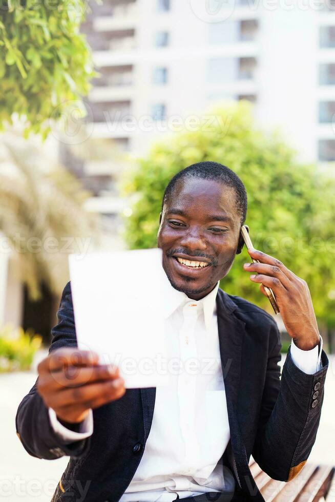 black man looking at picture and talking on phone photo