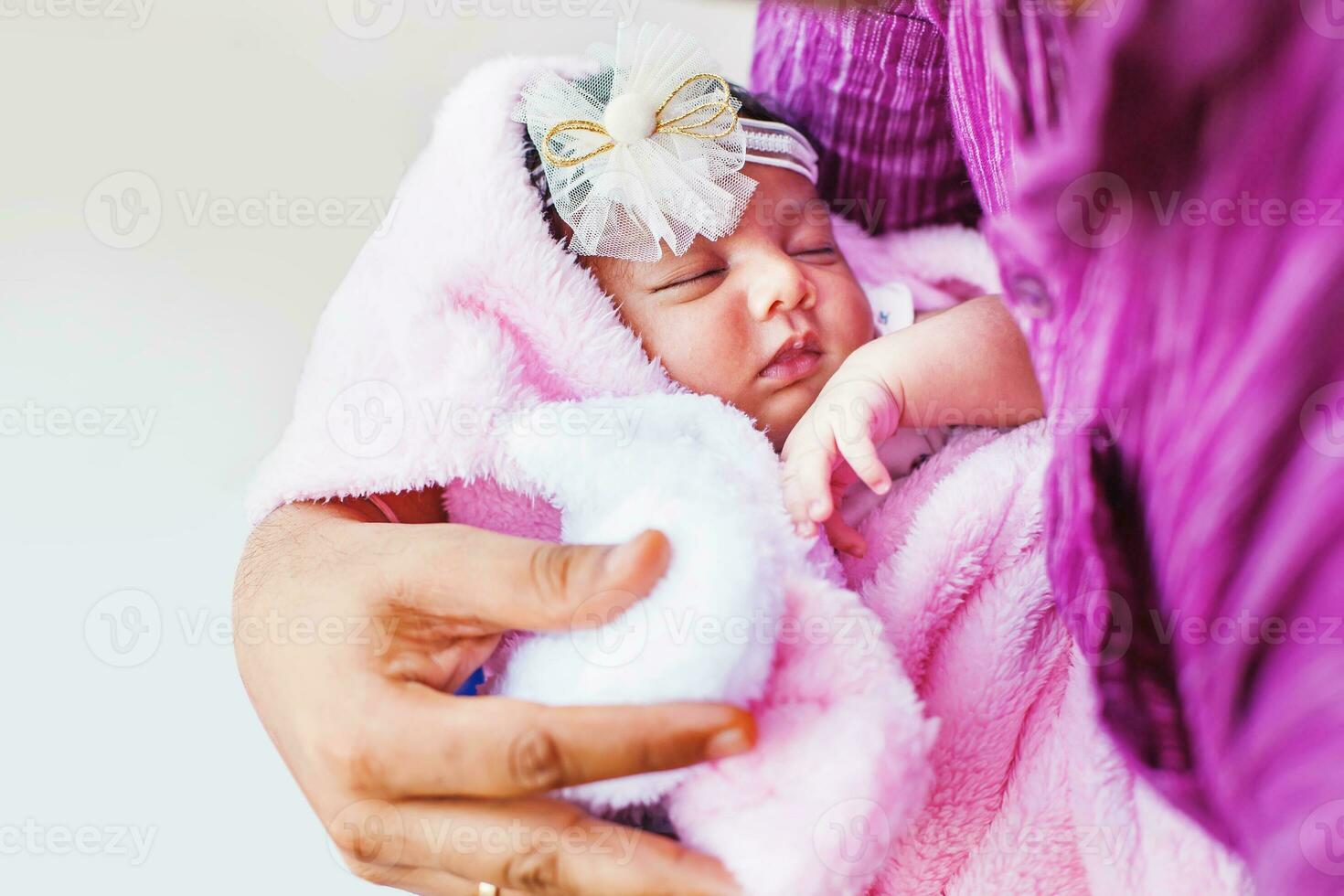 pequeño recién nacido indio niña dormido en el manos de su padre foto