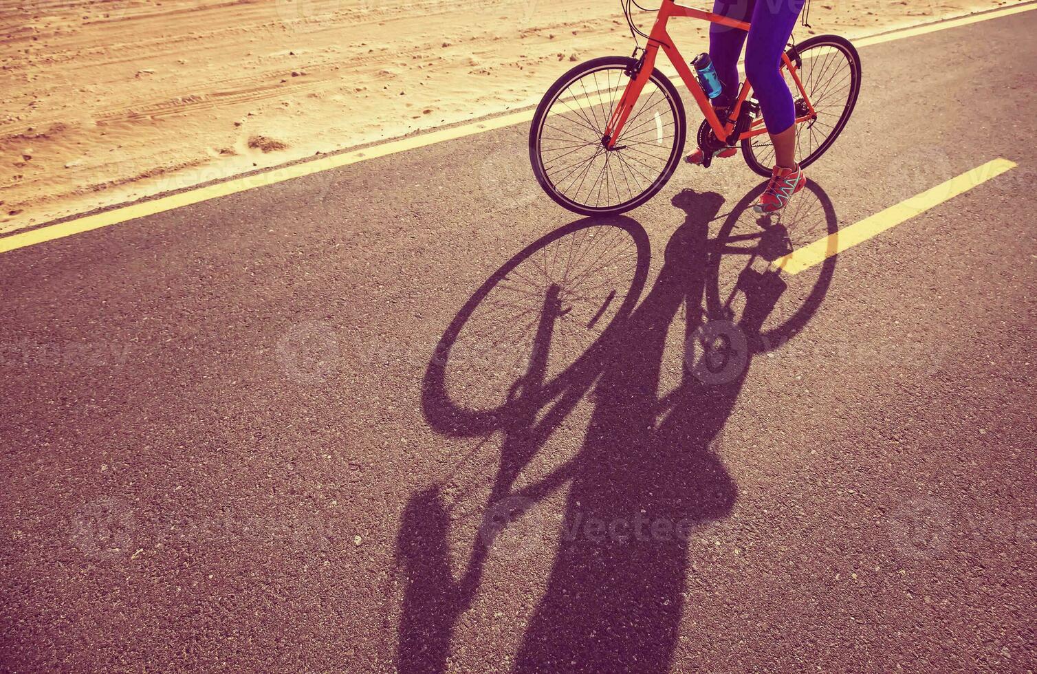 young caucasian woman riding bike in desert photo