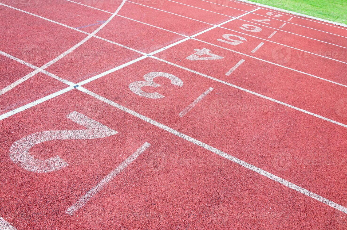 números comenzando punto en rojo corriendo pista, correr pista y verde hierba, directa atletismo corriendo pista a deporte estadio foto