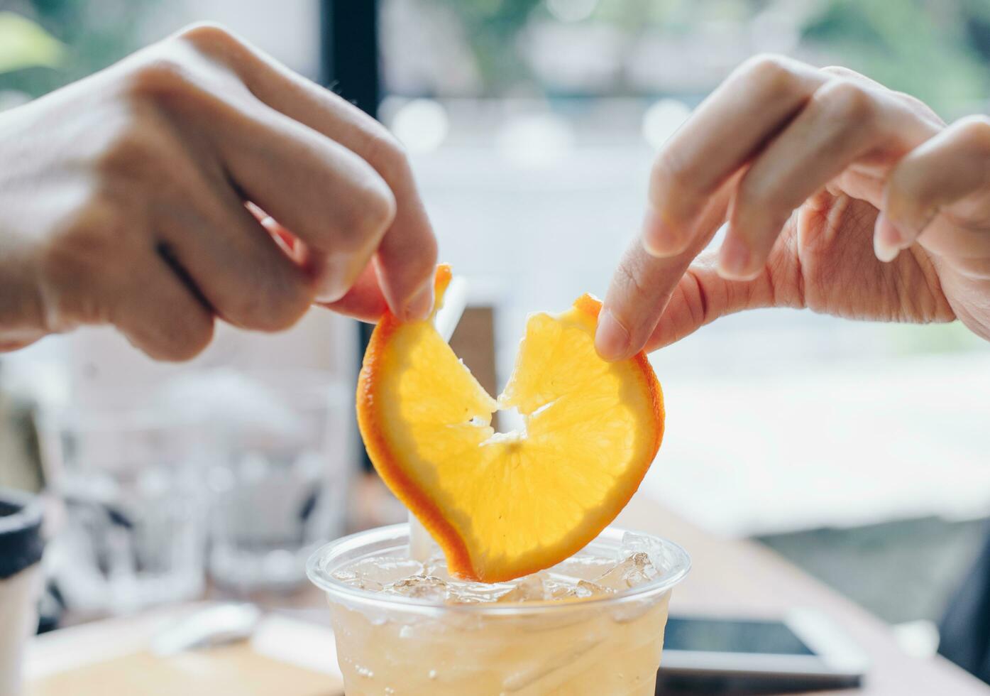 Human hands tearing a piece of orange. photo
