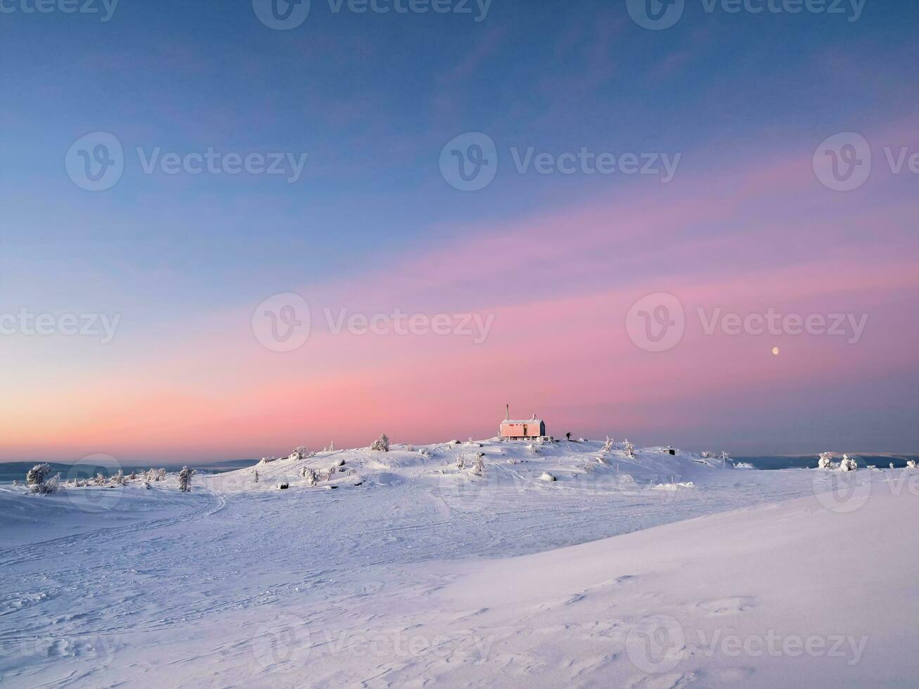 Cabin in winter. Dubldom on the mountain Volodyanaya Kandalaksha, Murmansk region in Russia. Holidays, vacations in winter. Beautiful Arctic sunset. Scenic colorful sky at dawn. Winter time. photo