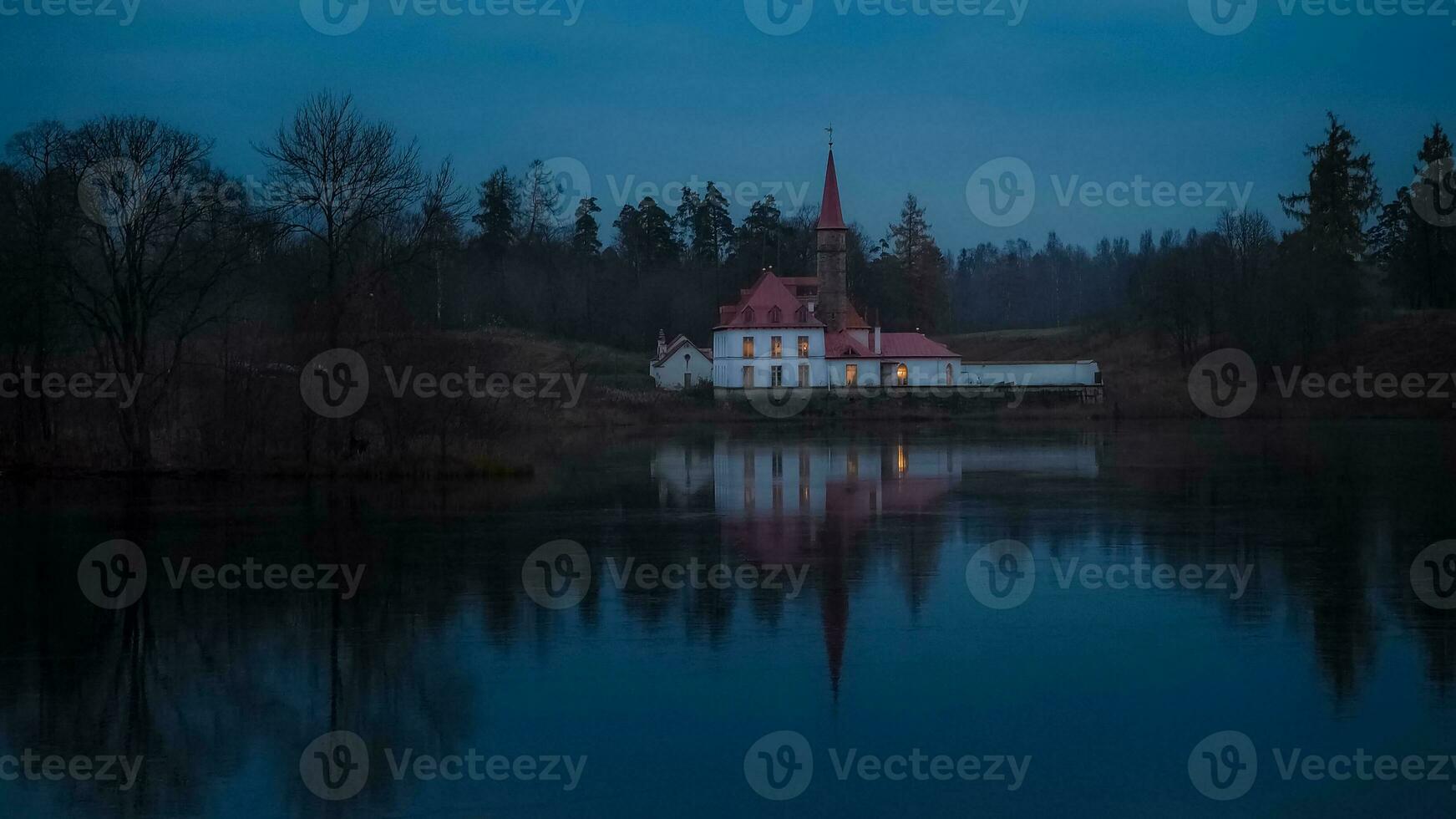 Castle by the dark evening lake photo