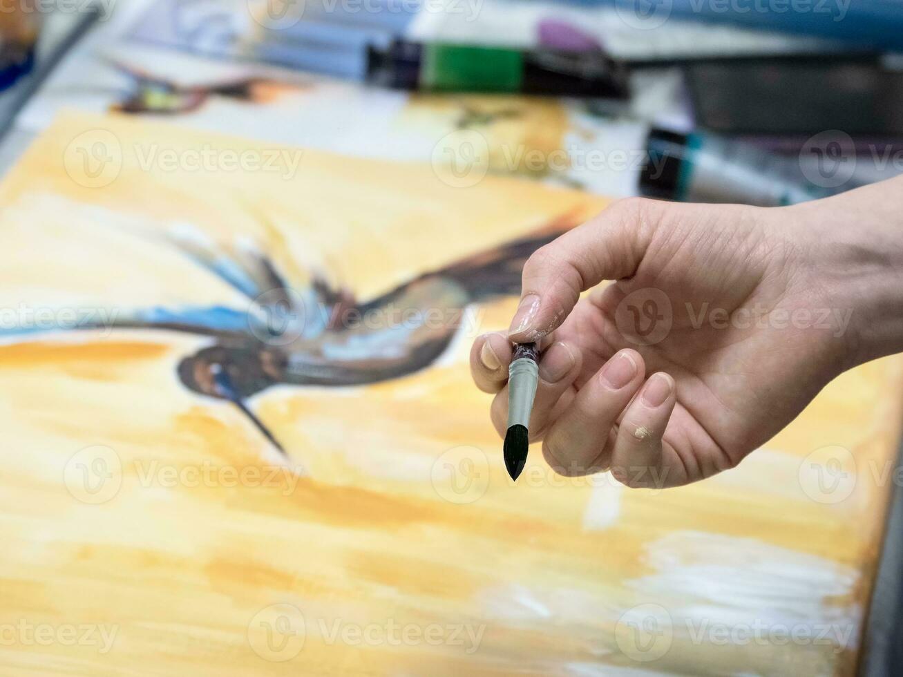 Selective focus. Brush in the hands of the artist, watercolor painting, creativity with many colors. photo
